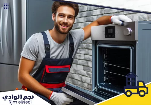فني صيانة يرتدي زي العمل ويبتسم بعد إتمام عملية إصلاح فرن المطبخ بنجاح.