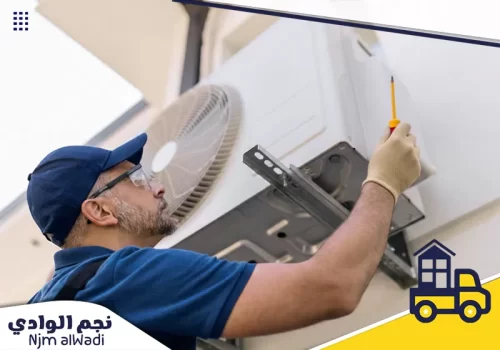 شركة تنظيف مكيفات بالدرعية 0535475547 نجم الوادي فني من شركة تنظيف مكيفات بالدرعية يستخدم مفكاً لصيانة الوحدة الخارجية للمكيف.
