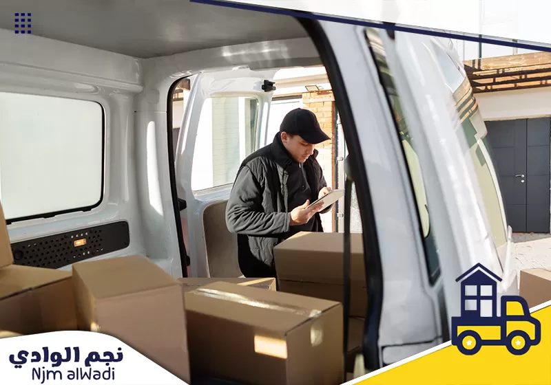 عامل نجم الوادي يرتب كراتين الأثاث داخل سيارة النقل استعدادًا لتوصيل العفش للموقع المطلوب.